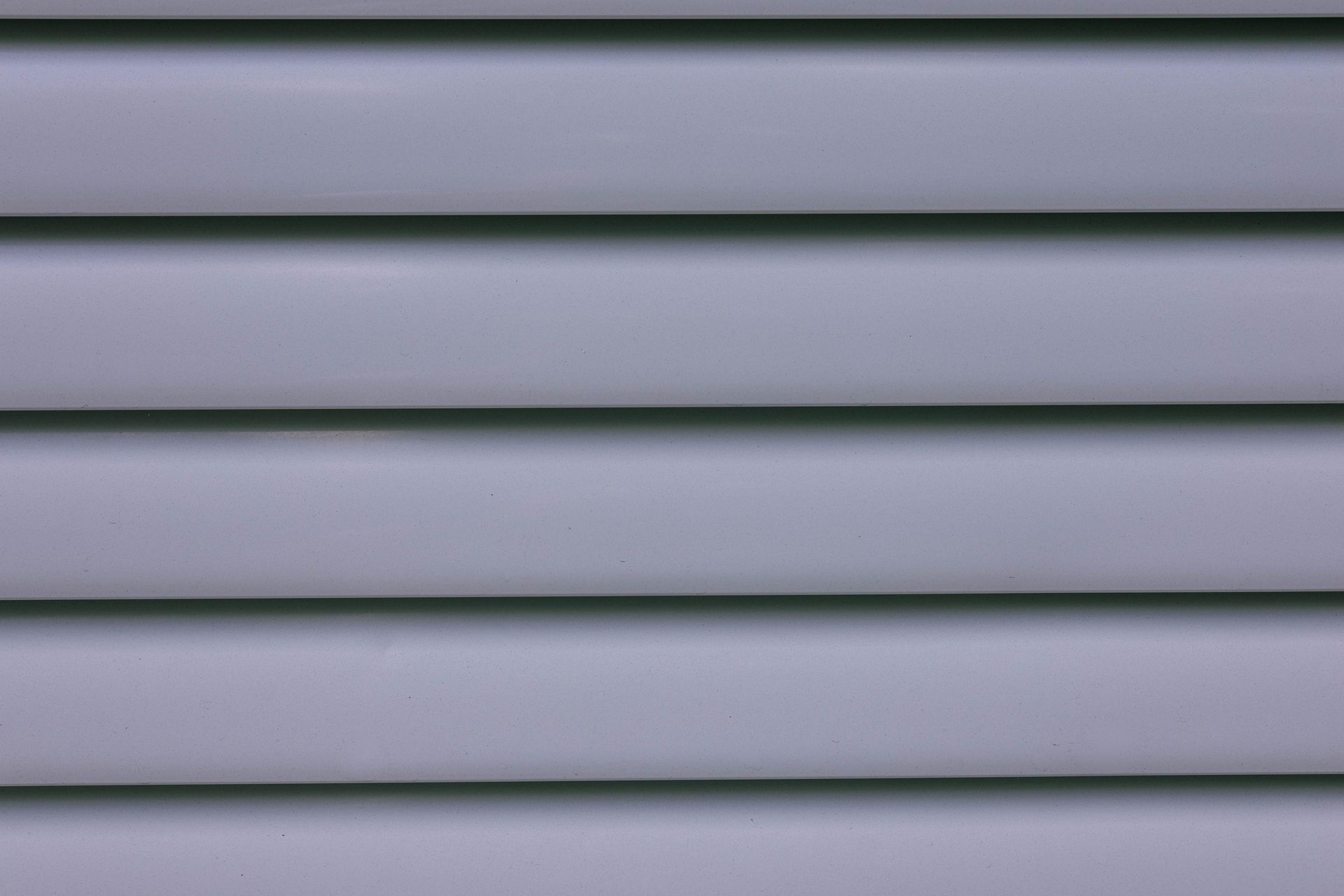 Detailed close-up of gray layered wall paneling showing lines and shadows.